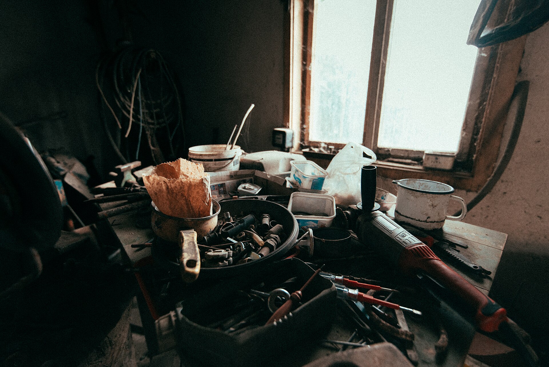 Cluttered workbench in a rustic workshop filled with tools and materials.jpg — illustrating Kit vs Bare Tool: What Do They Mean and When Each Wins