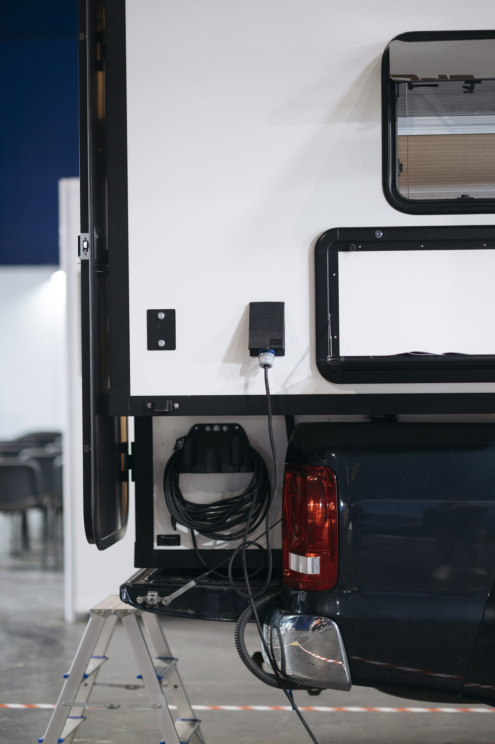 Detailed view of a camper vehicle being connected to a power supply in a workshop setting.jpg — illustrating Air Tools vs Cordless Tools: What's the Real Difference?